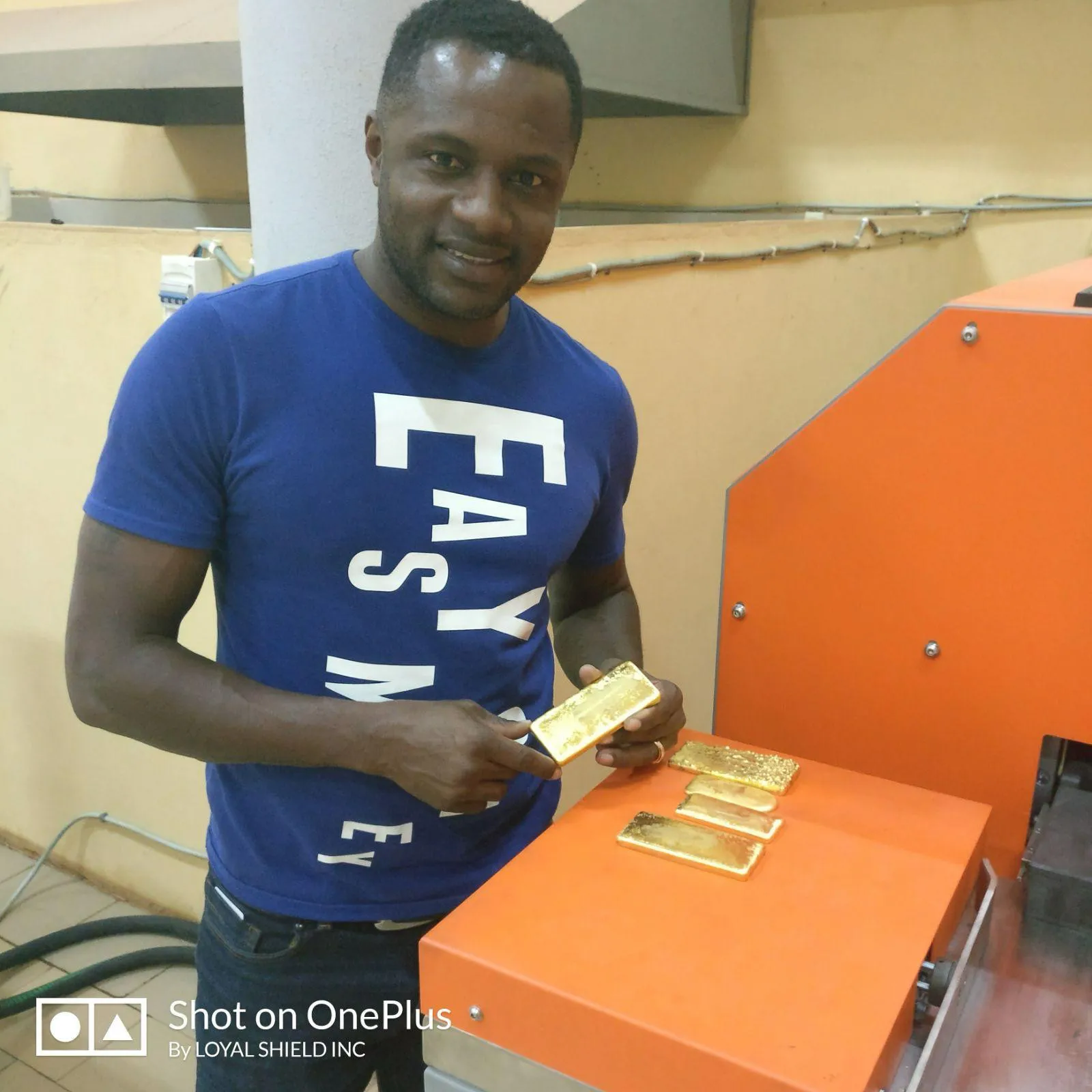 Pierre Olivier Bakalag holding a cast gold bar at the refinery.
