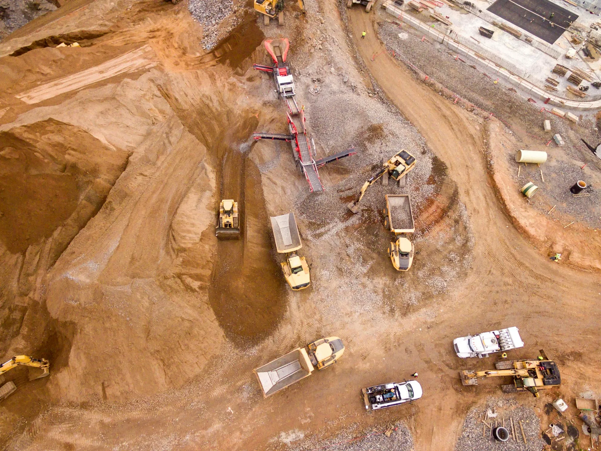 Aerial view of mining dump trucks at work in an open-pit operation.