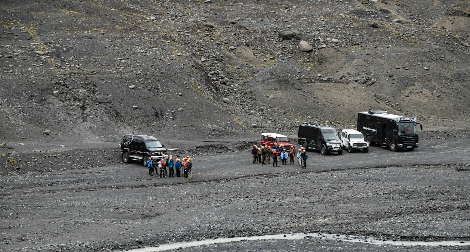 Operations team gathered at vehicles on a mining site.